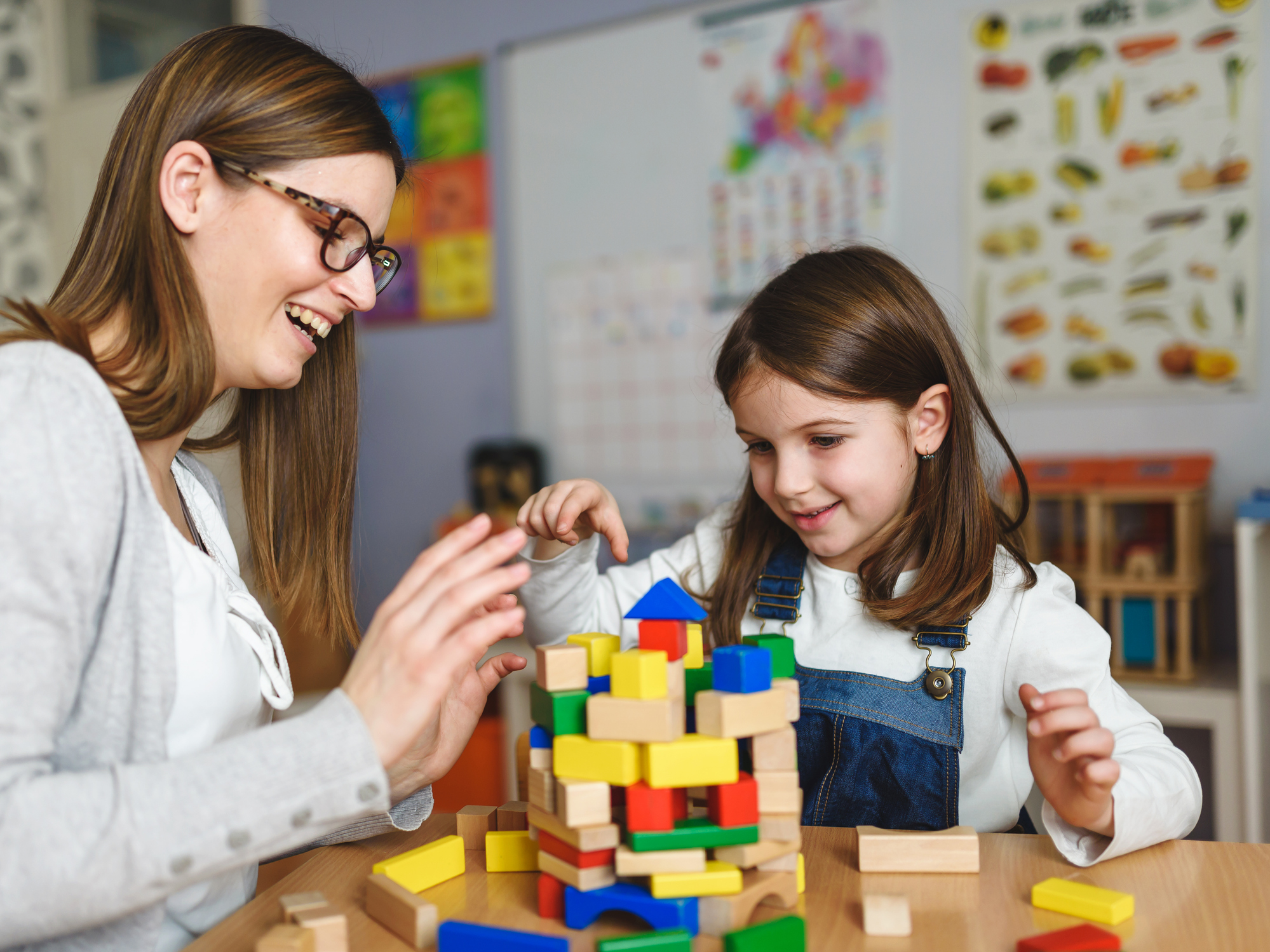 Mother and Daughter Playing Together with colorful building toy blocks