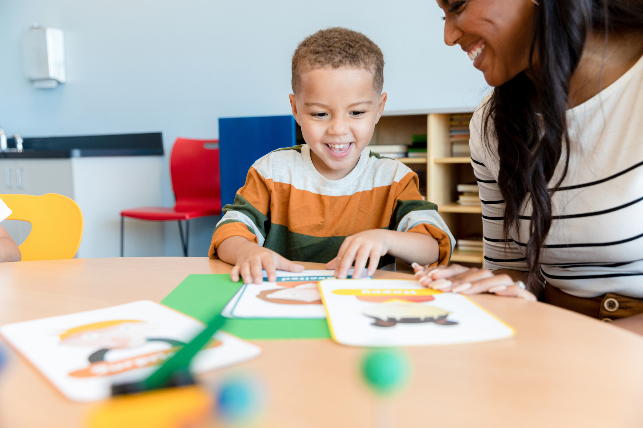 Young boy imitates emotion flash cards