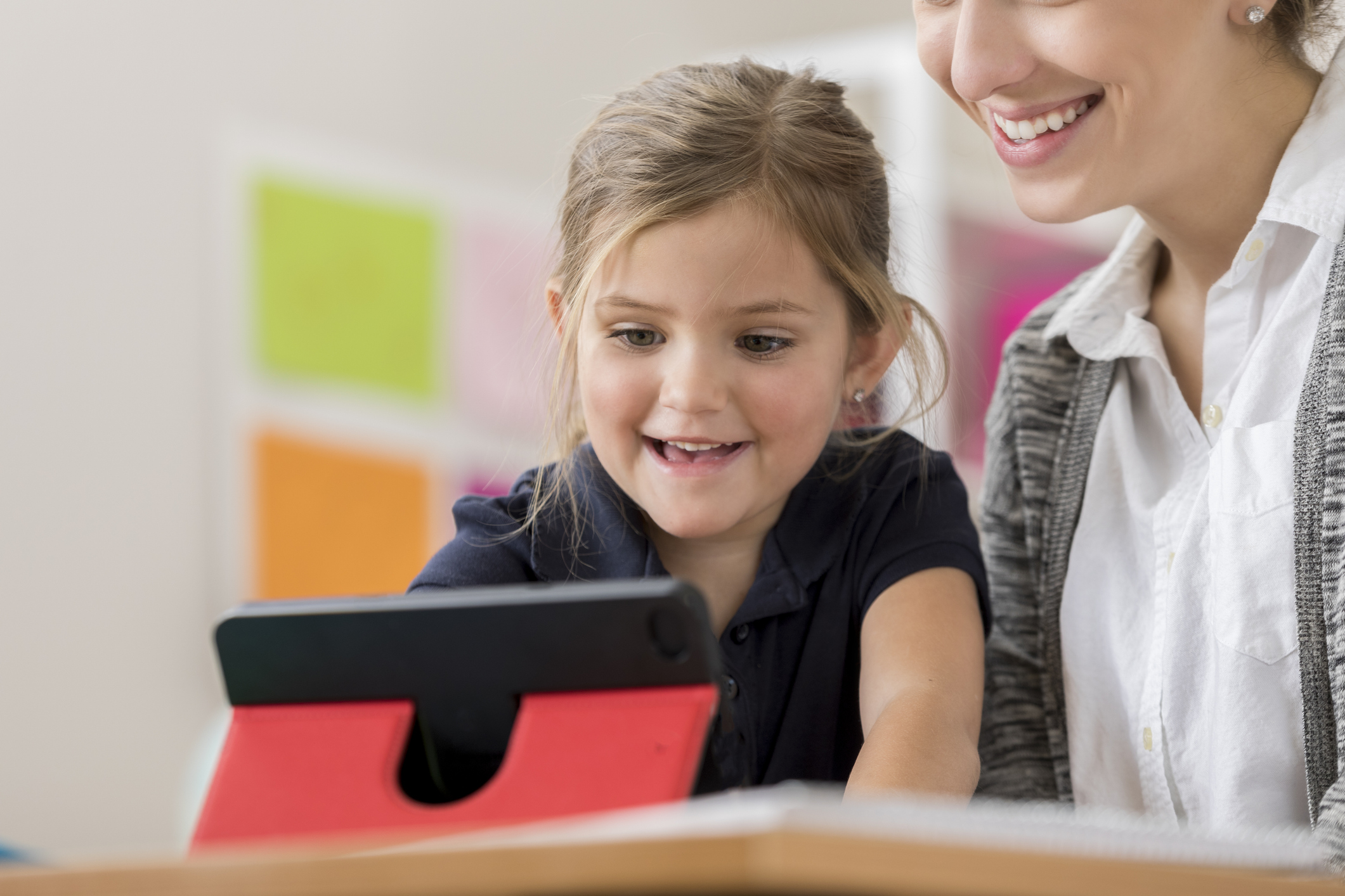 Cheerful elementary student enjoys using digital tablet
